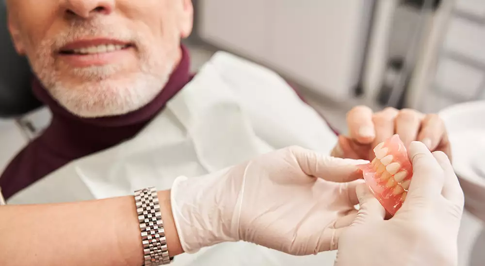 Dental Assistant Showing a Patient Full Dentures